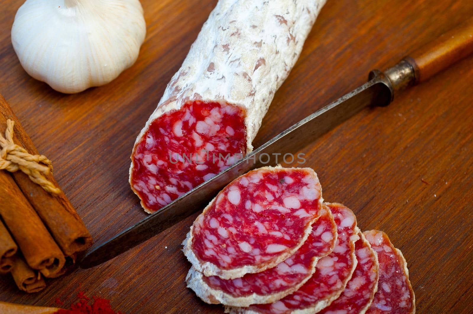 traditional Italian salame cured sausage sliced on a wood board