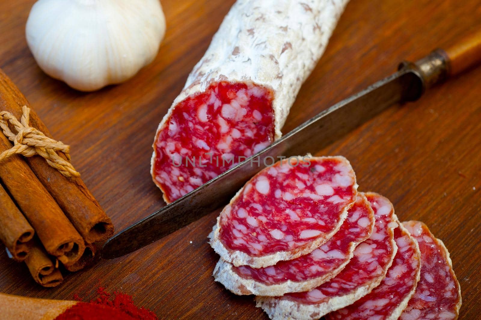 traditional Italian salame cured sausage sliced on a wood board