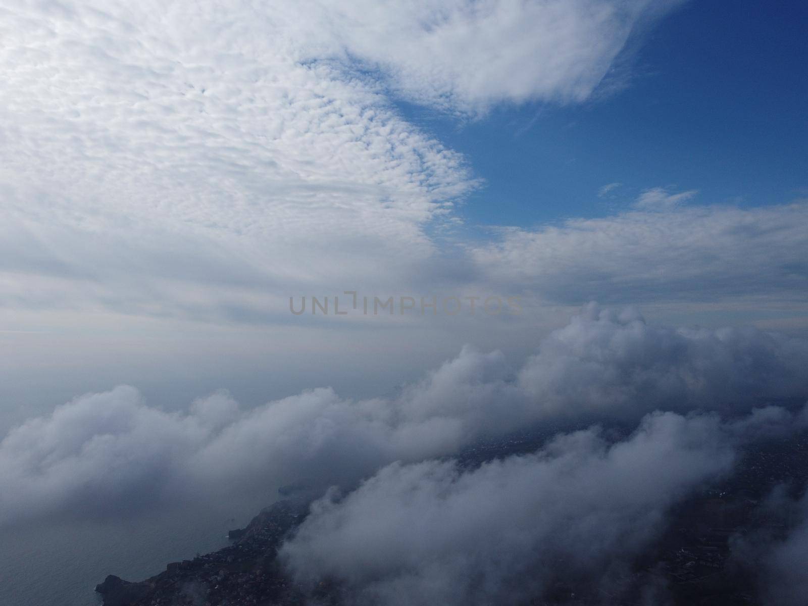 Camera is raising above from the thick fog above the beautiful ocean of clouds at sunrise. Sun is rising above the endless sea of clouds until the horizon. Amazing nature landscape, 4K drone in sky