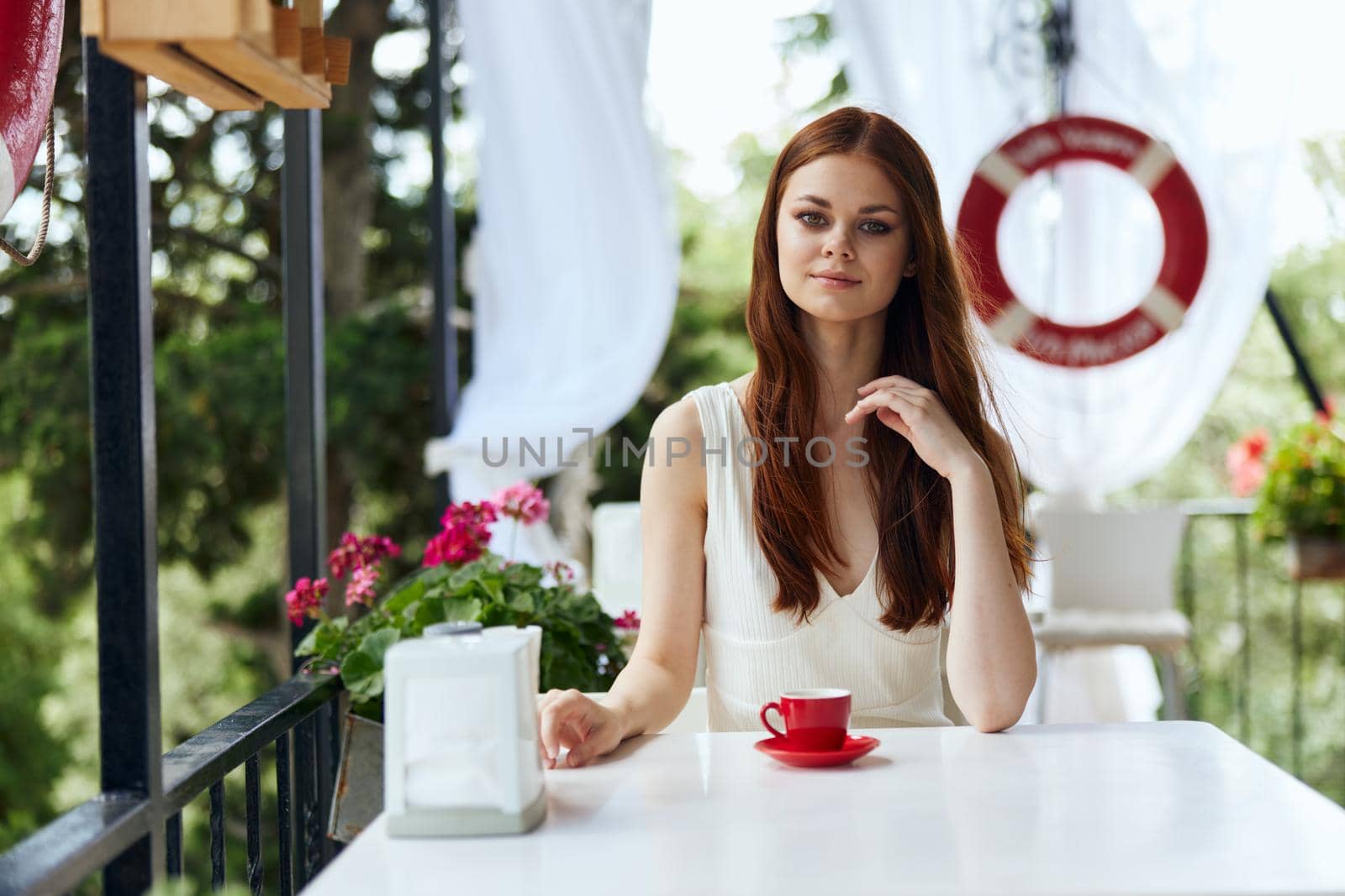beautiful woman sitting in outdoor cafe street drink coffee unaltered. High quality photo