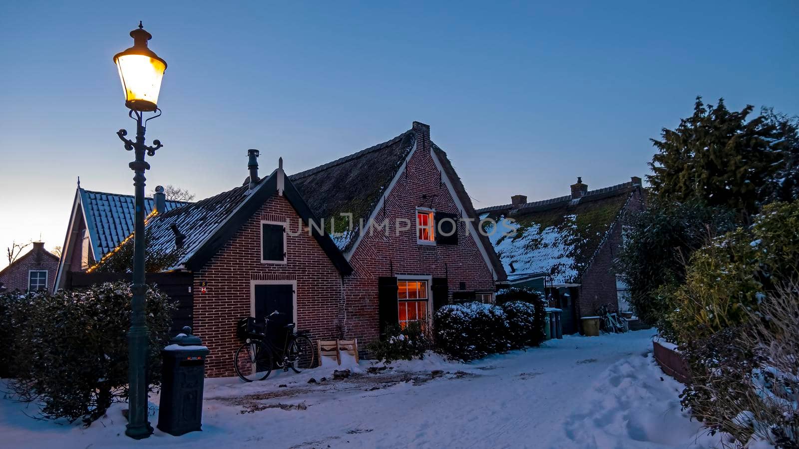 Snowy old traditional dutch houses in the countryside from the Netherlands in winter by devy