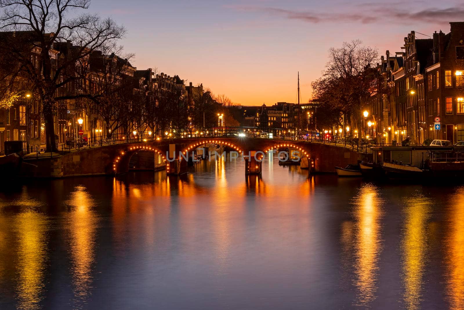 City scenic from Amsterdam at the river Amstel in the Netherlands at sunset