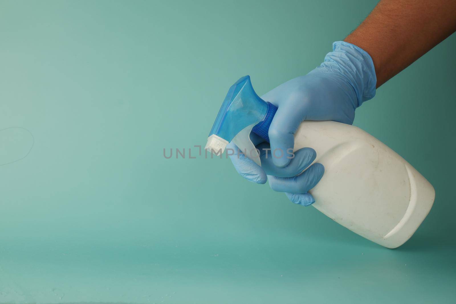 using disinfectant spray to clean table surface.