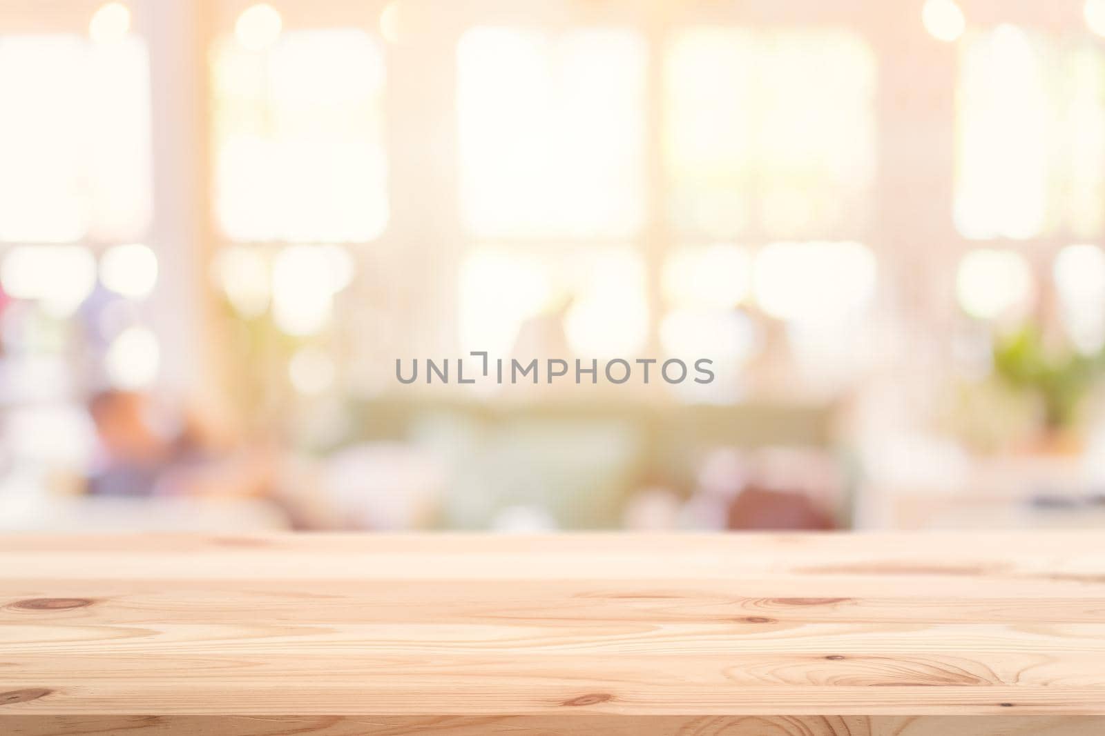 Wooden table top foreground with blurred indoor cafe shop and restaurant background for products display montage advertising banner.