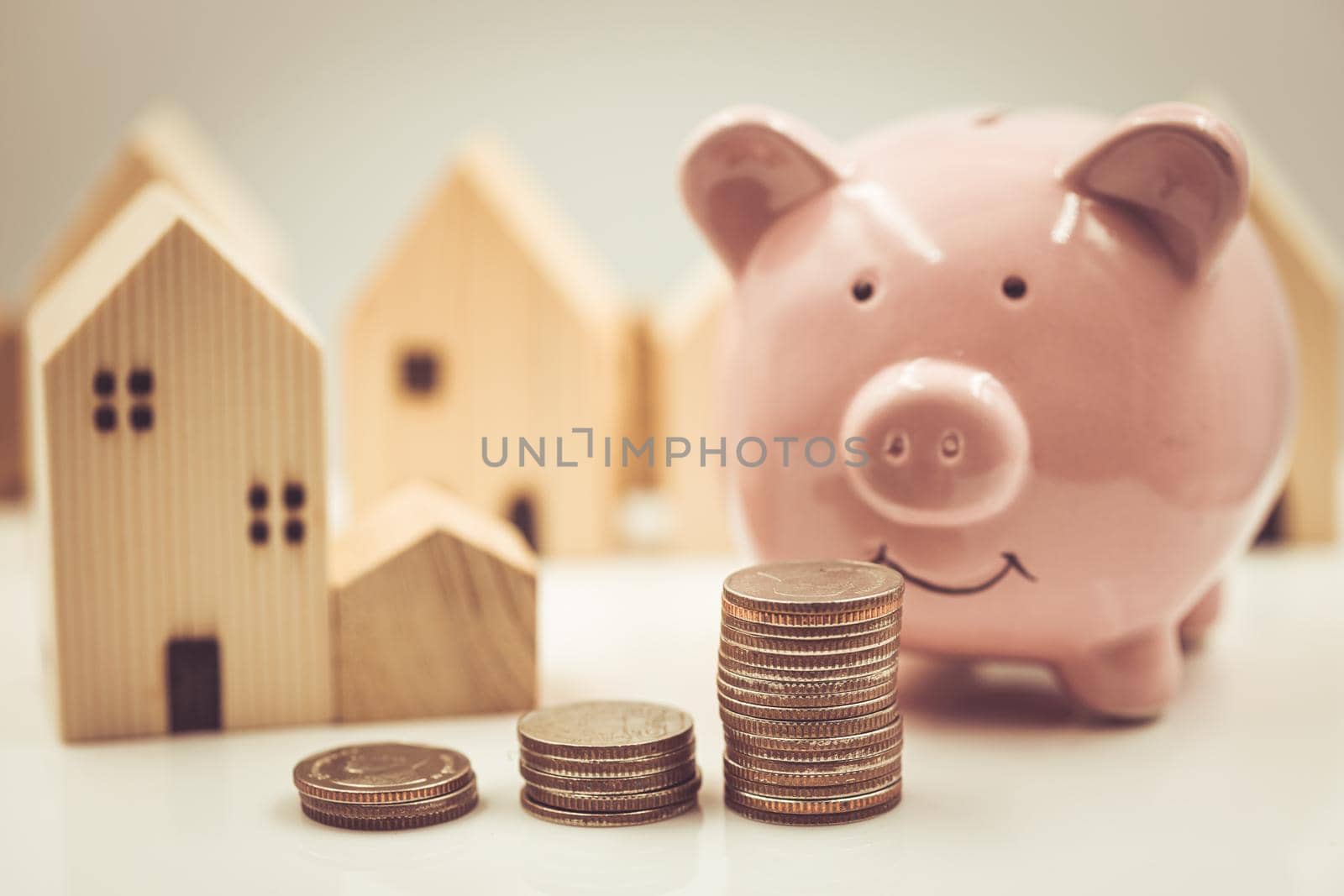 Happy saving money for home concept. Piggy bank with money and home model vintage color tone.