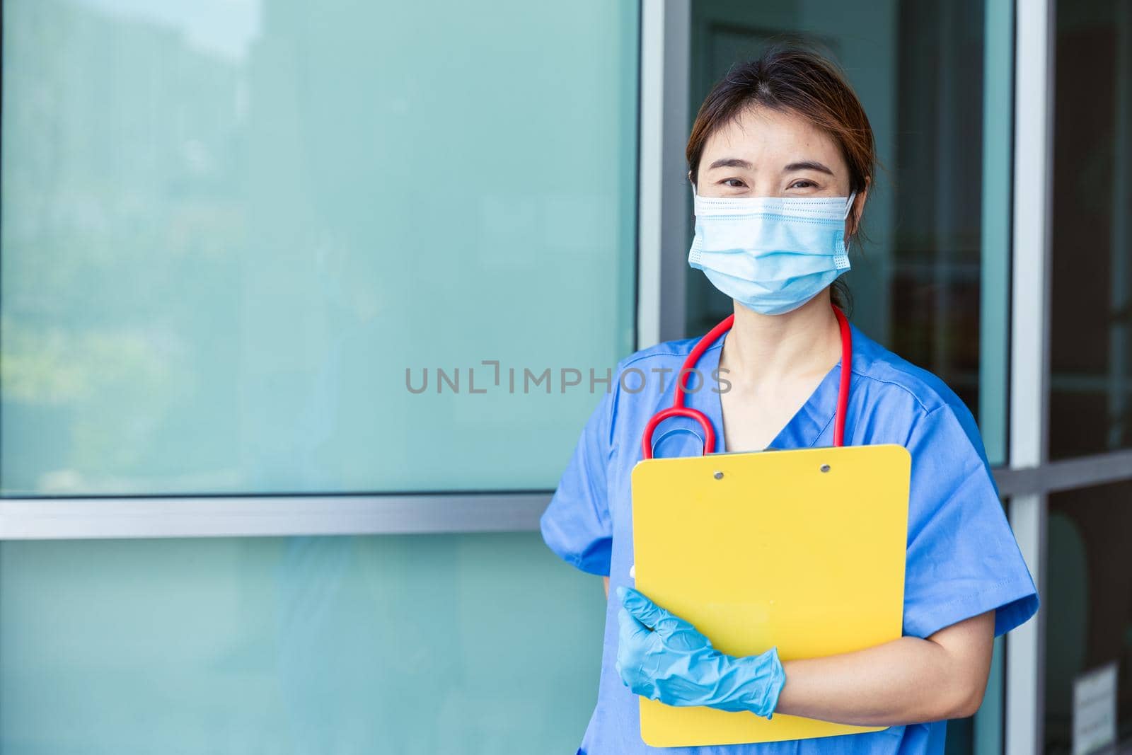 Portrait Asian nurse medical staff standing with face mask in hospital with space for text.