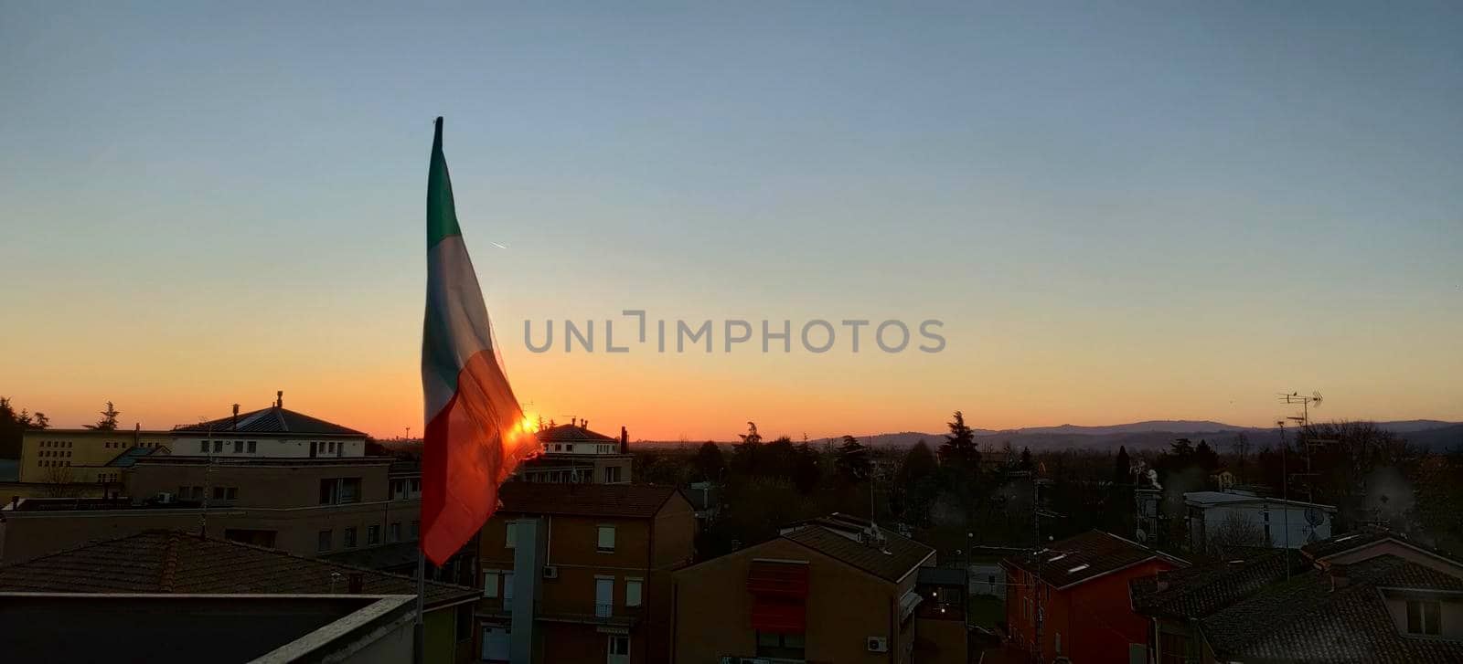 beautiful sunset over small country bibbiano reggio emilia with italian flag, high quality photo
