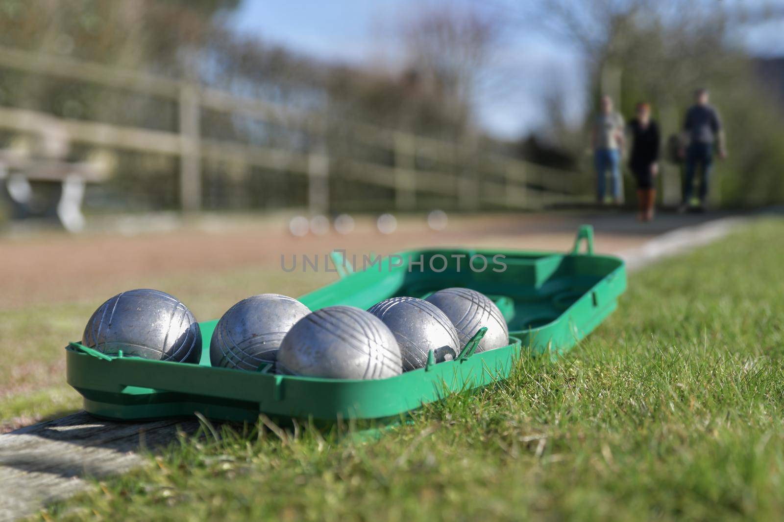 Petanque balls in a green box on the grass