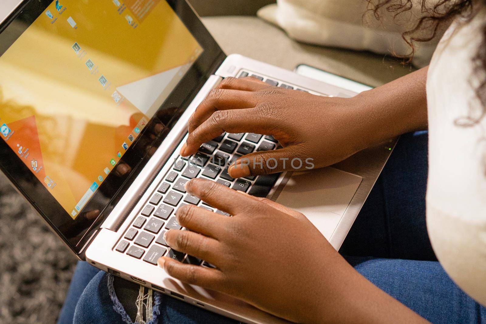 Female Hands Typing on the Laptop Keyboard, Dark Skinned Person Working on Laptop. Close-up of Hands on Laptop. High quality photo