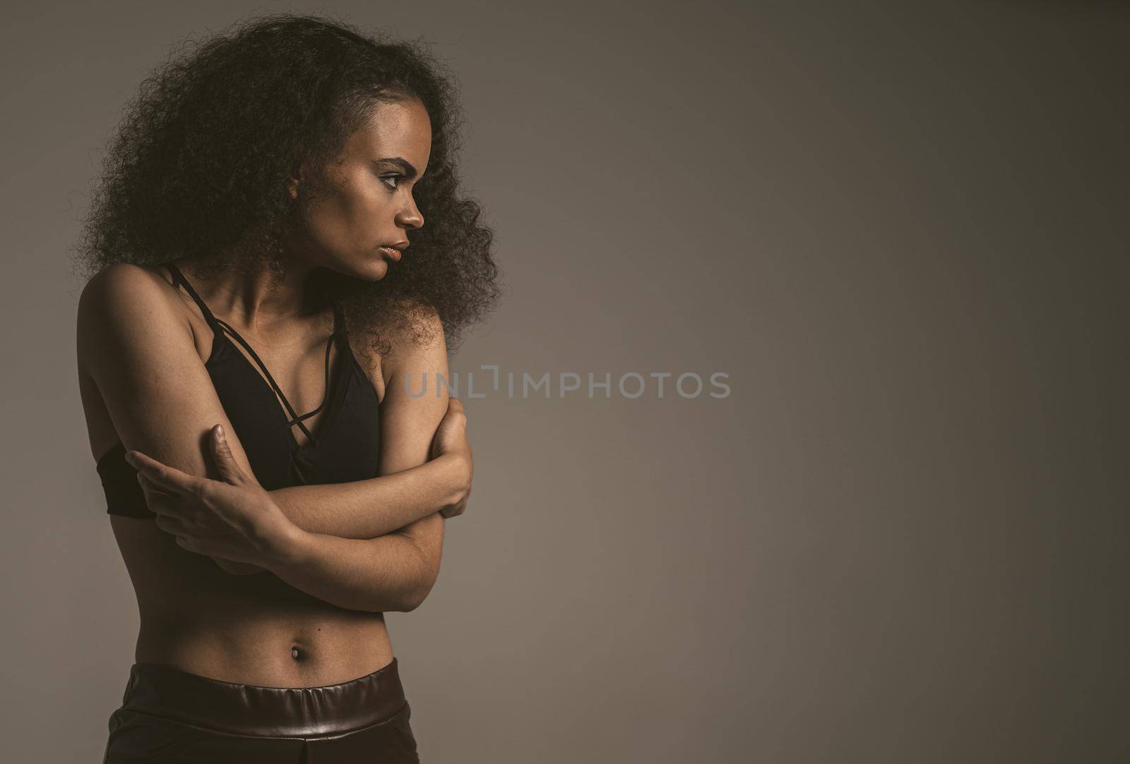 Timidity, panic attack, self-preservation, fear African American girl standing covered with hands in black bare shoulder top isolated on grey background. Human emotions, facial expression concept.