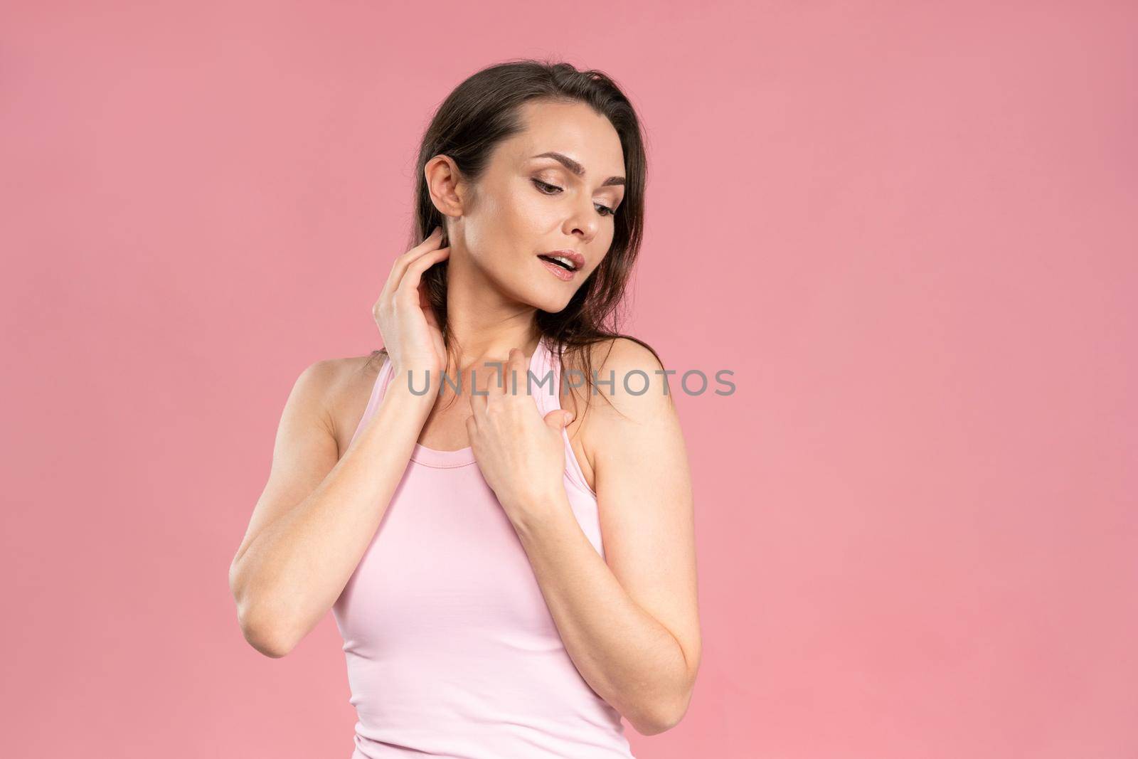 Portrait of a beautiful young female with no makeup, skin care concept, attractive brunette girl on pink background. Human emotions, facial expression concept. Facial expressions, emotions, feelings.