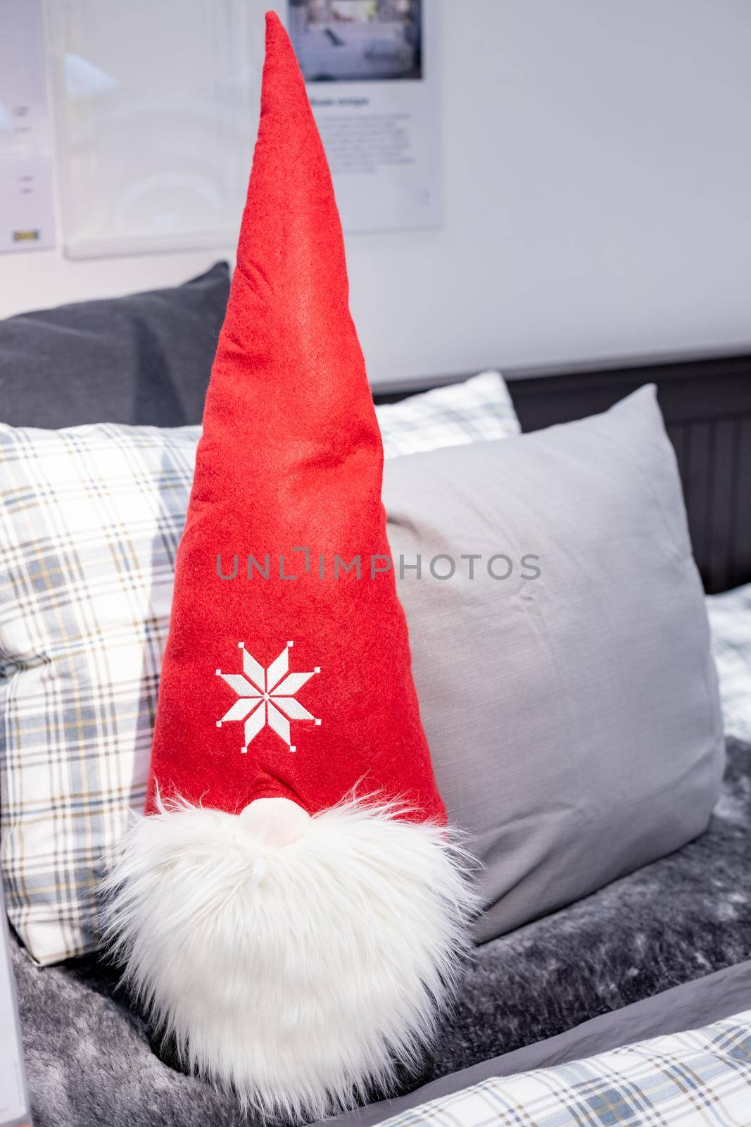 cute Scandinavian Christmas dwarf sitting on the pillows.