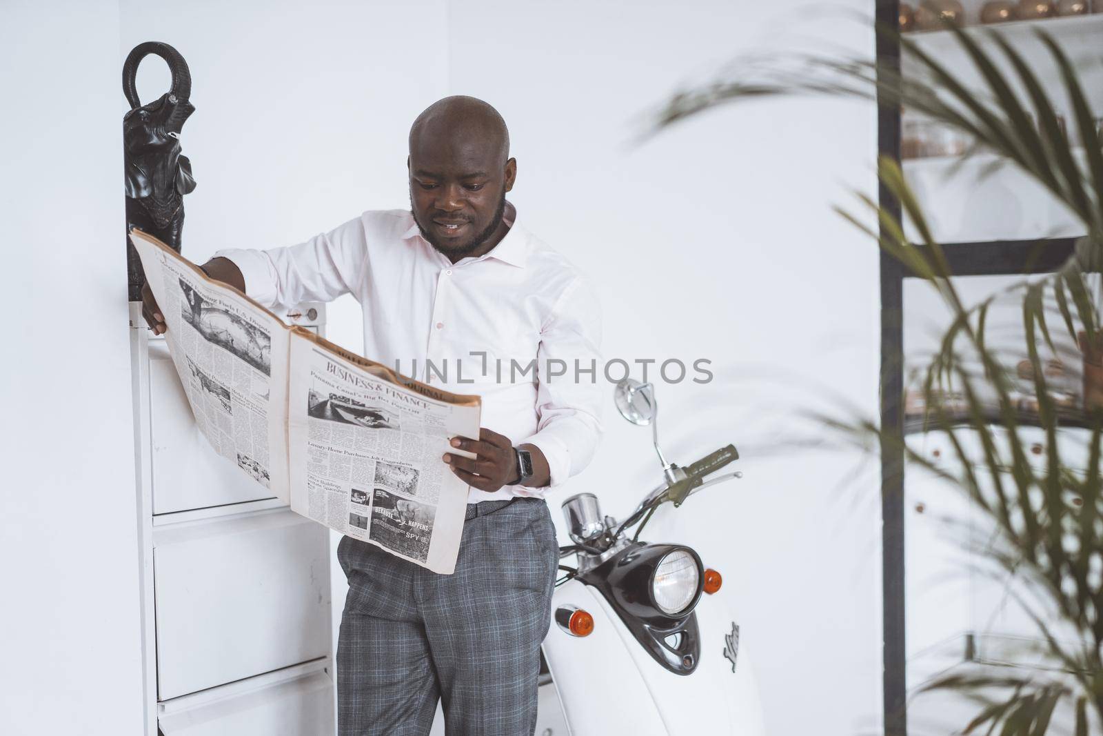 Successful Young Businessman. African American Guy After Business Trip Looks At News In Newspaper. Wealthy Business Owner Stands In Lobby. Concept Personal Growth. High Quality Photo