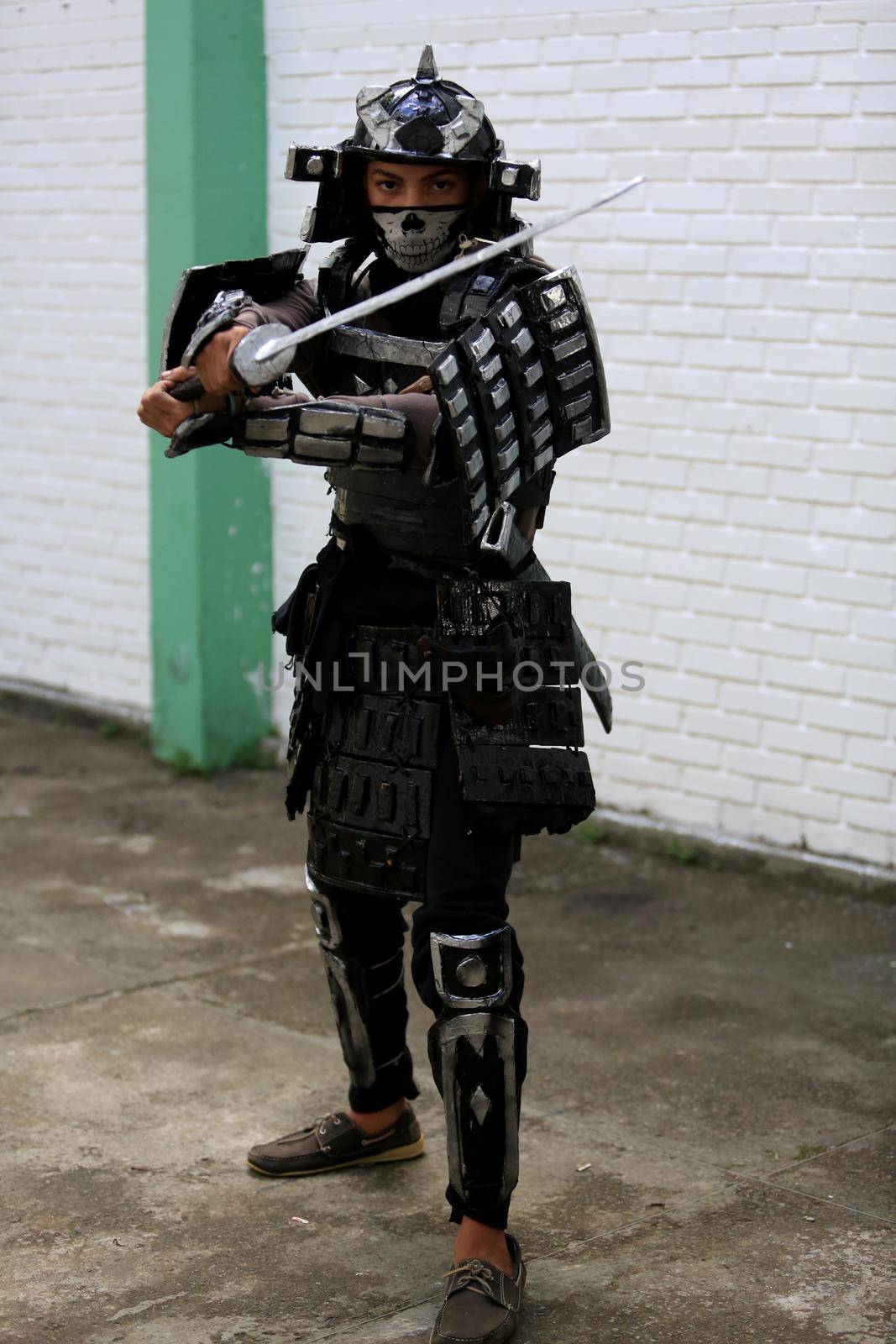 salvador, bahia, brazil - april 24, 2017: Young man wears armor made of imitation paper warrior with armor in Salvador city.