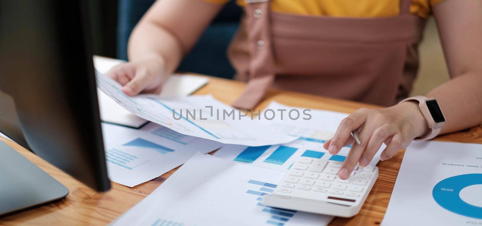 woman accountant making working audit and calculating expense financial annual financial report balance sheet statement, doing finance making notes on paper checking inspection. by wichayada