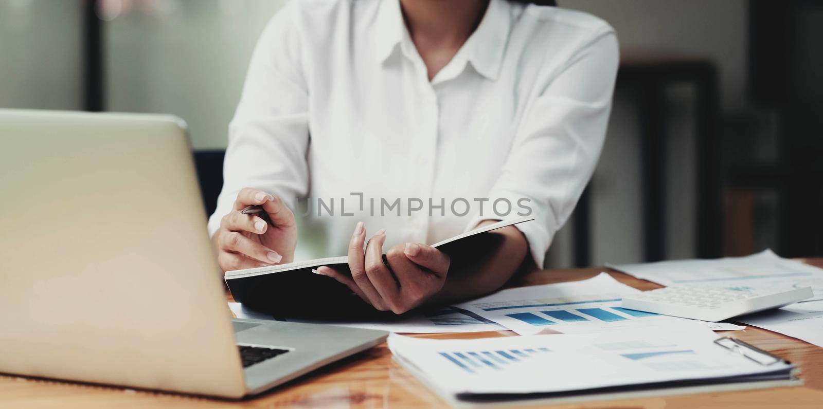 Businesswoman investment consultant analyzing company annual financial report balance statement working with documents graphics. by wichayada