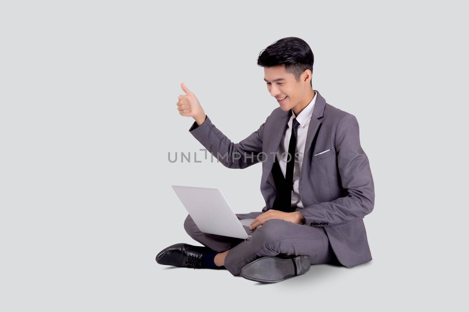 Young asian business man sitting work on laptop computer to internet online isolated on white background, businessman confident and notebook, freelance with success, marketing and communication. by nnudoo