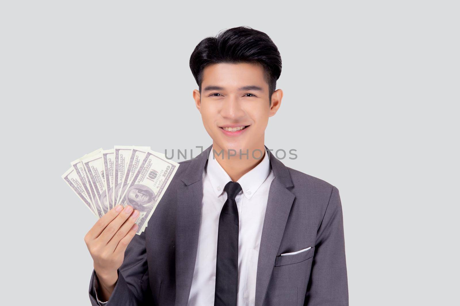 Young asian business man holding money dollar isolated on white background, businessman in suit holding banknote and success and excited with finance, savings and investment, income and spending. by nnudoo