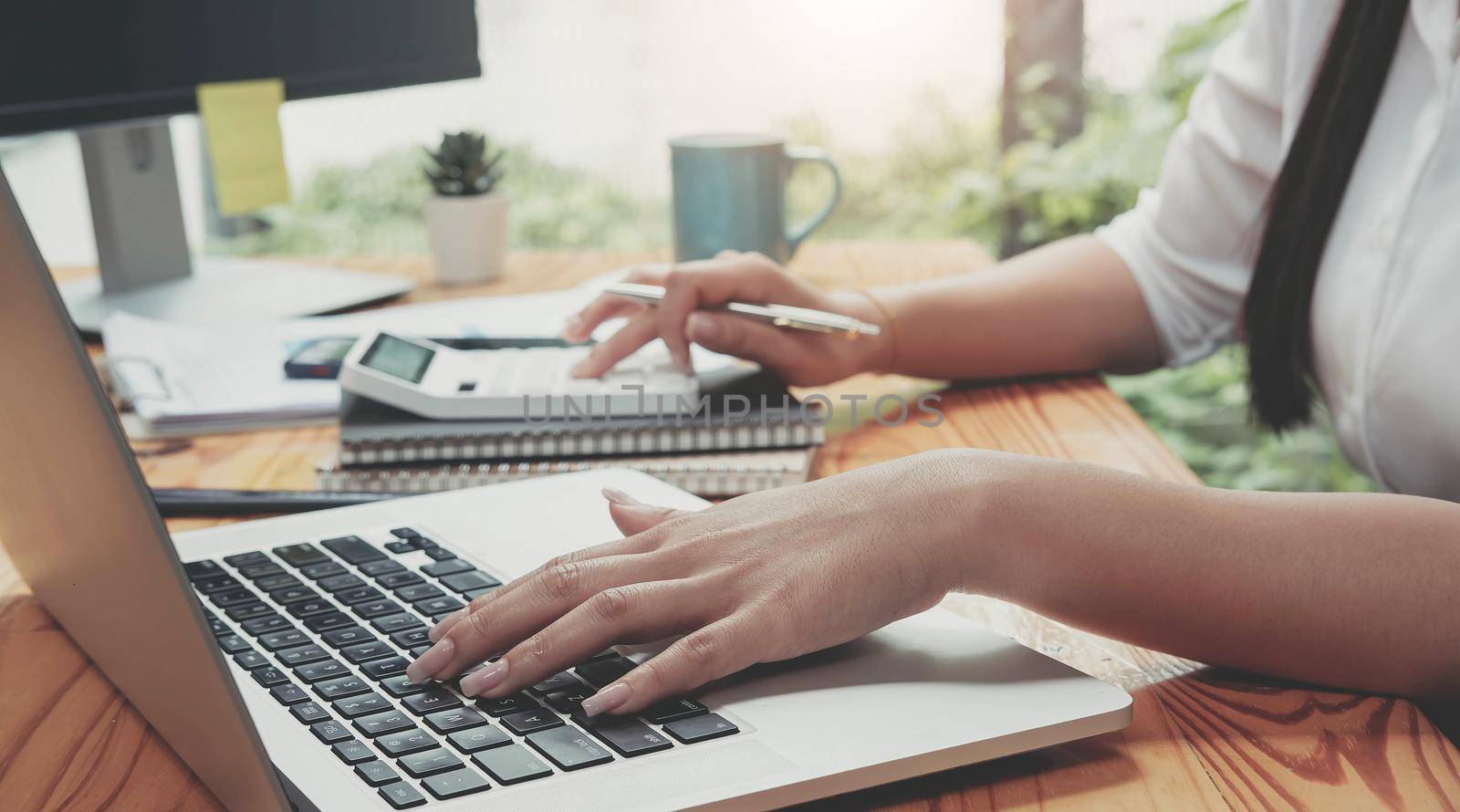 Woman accountant working with computer and calculator for business and financial expense.