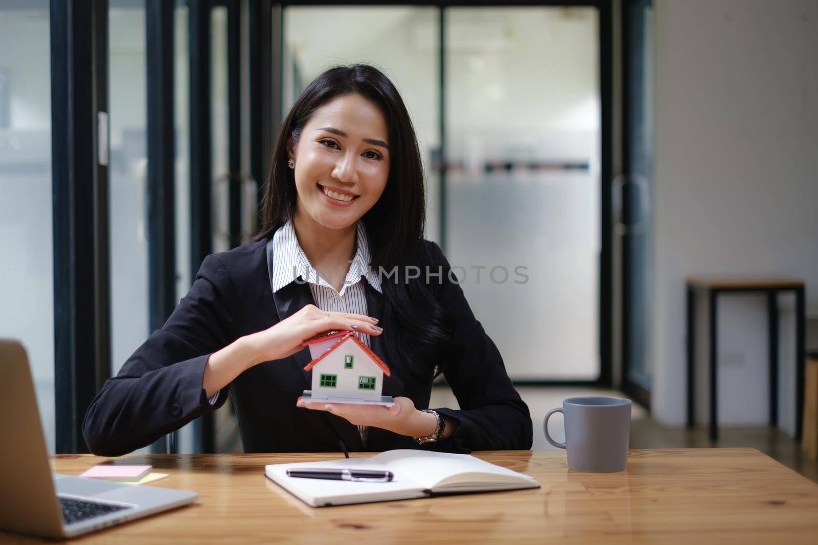 A real estate agent demonstrates the House model to clients interested in purchasing house insurance. The concept of home insurance and property by itchaznong