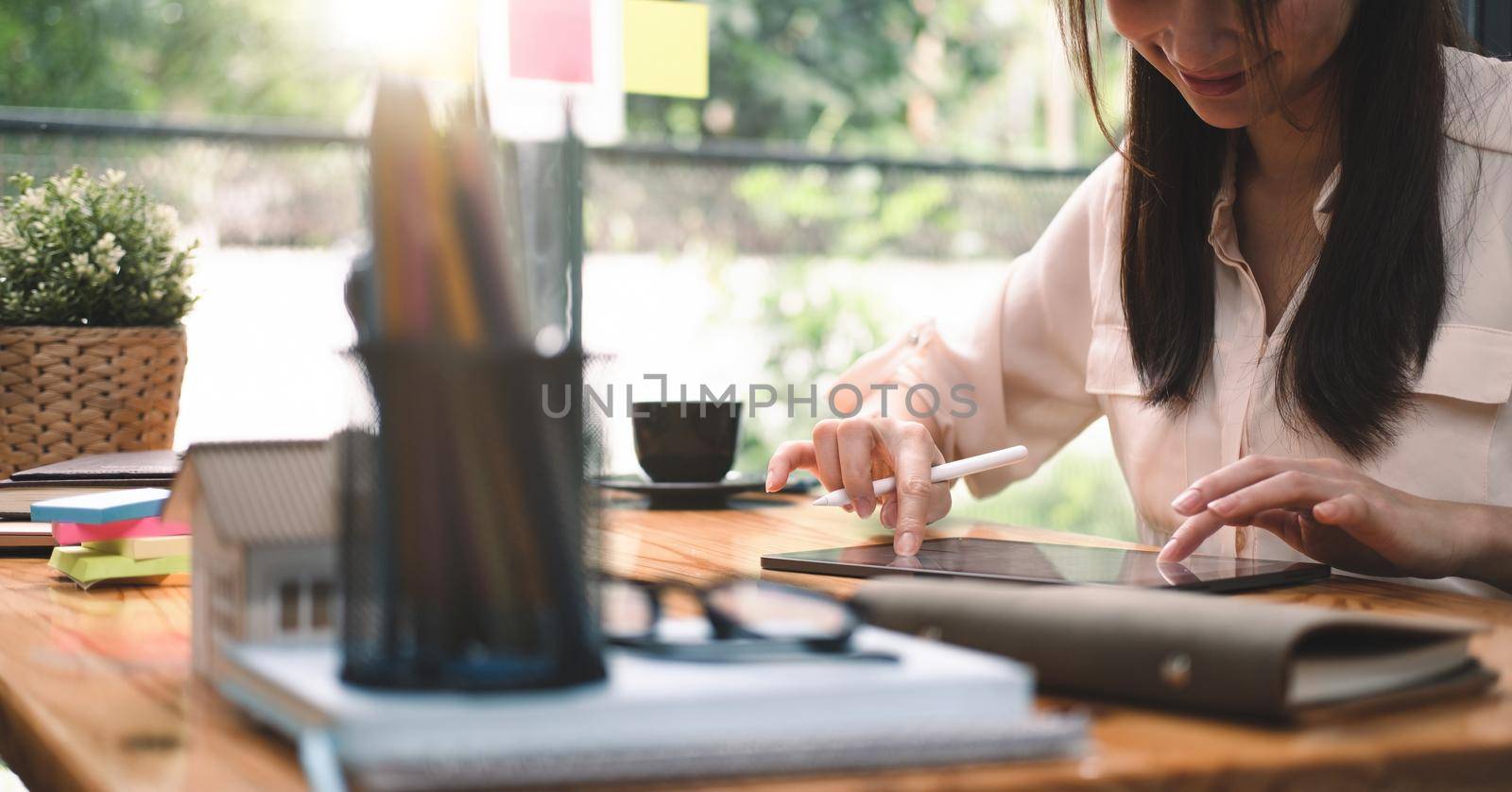 Close up asian woman using computer tablet with stylus at her office. business working concept by nateemee
