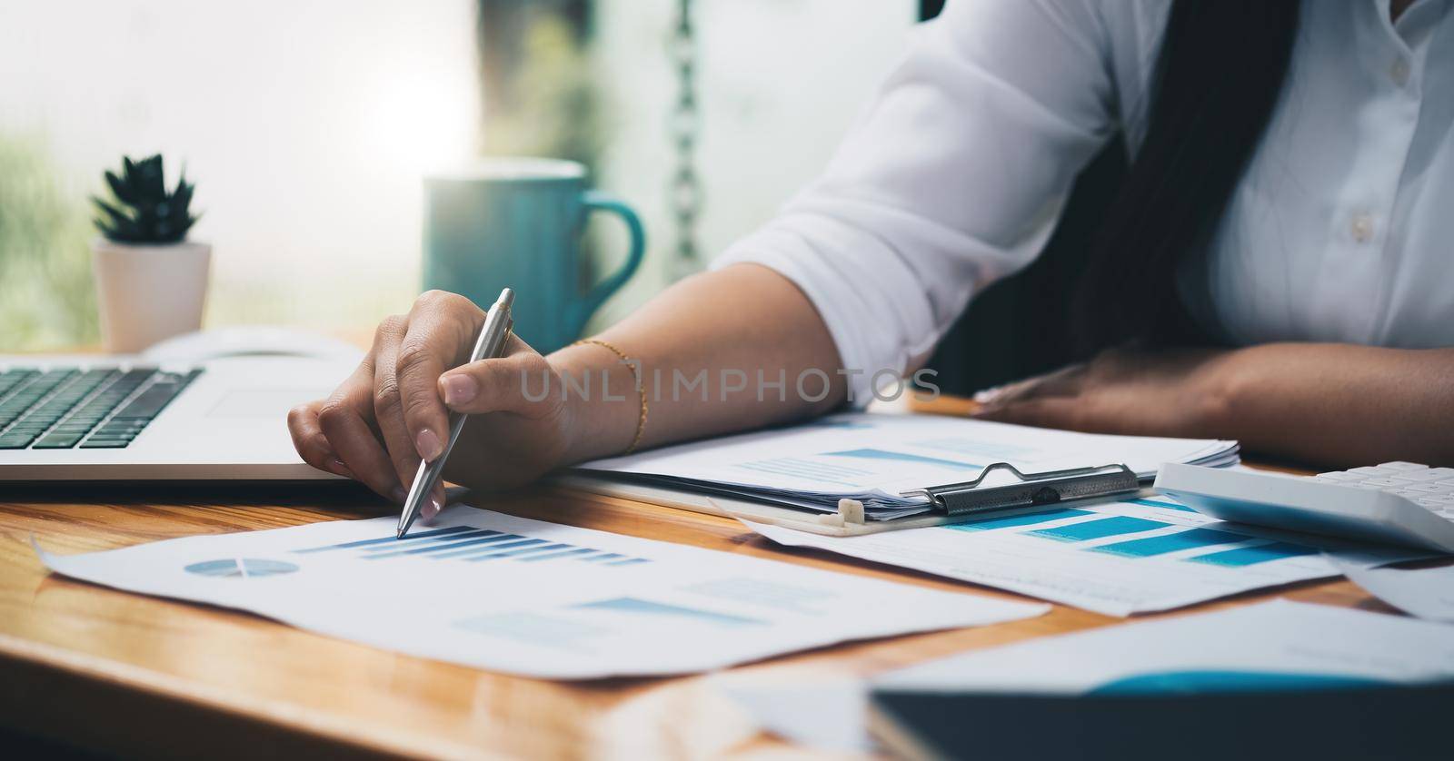 Business analyst working - hand with pen, calculator, coffee, magnifier, worksheet and graph, business financial concept.