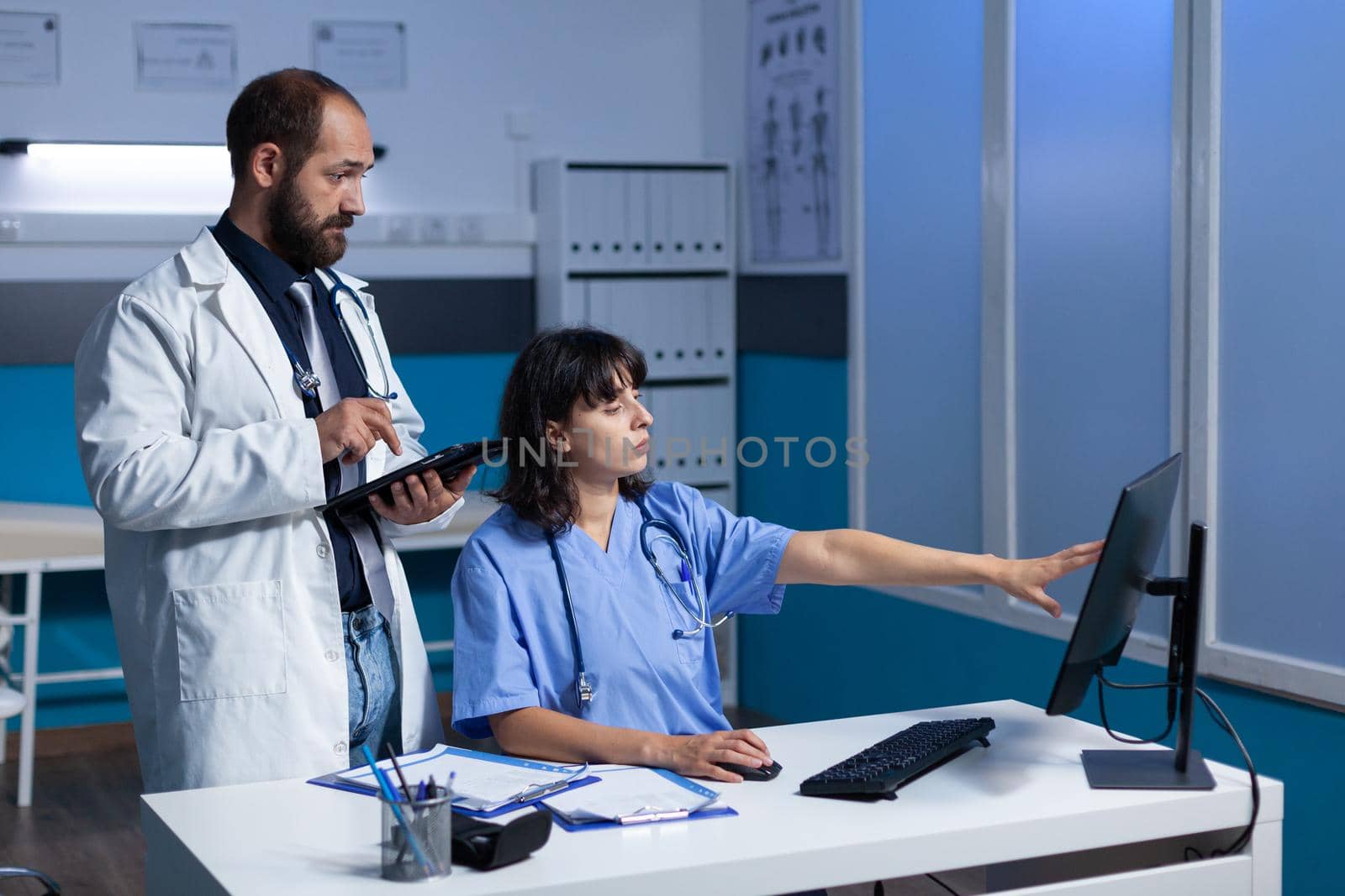 Team of medical specialists looking at computer screen by DCStudio