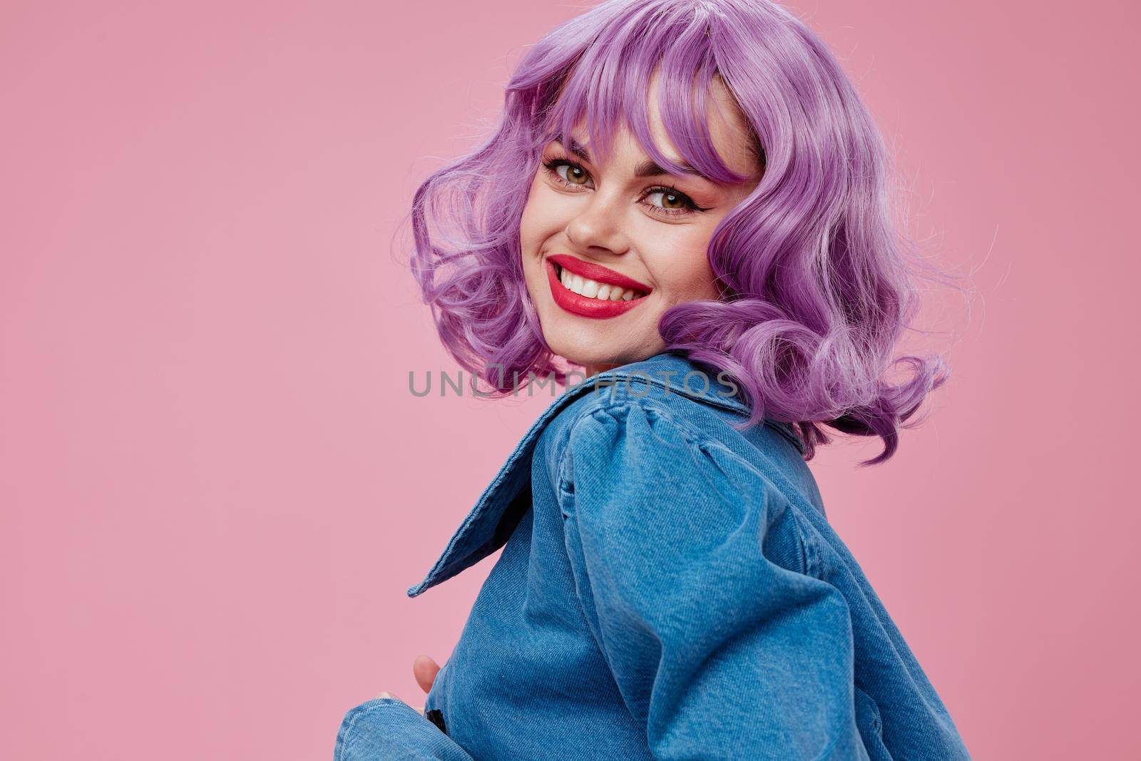 Positive young woman wavy purple hair blue jacket emotions fun studio model unaltered by SHOTPRIME