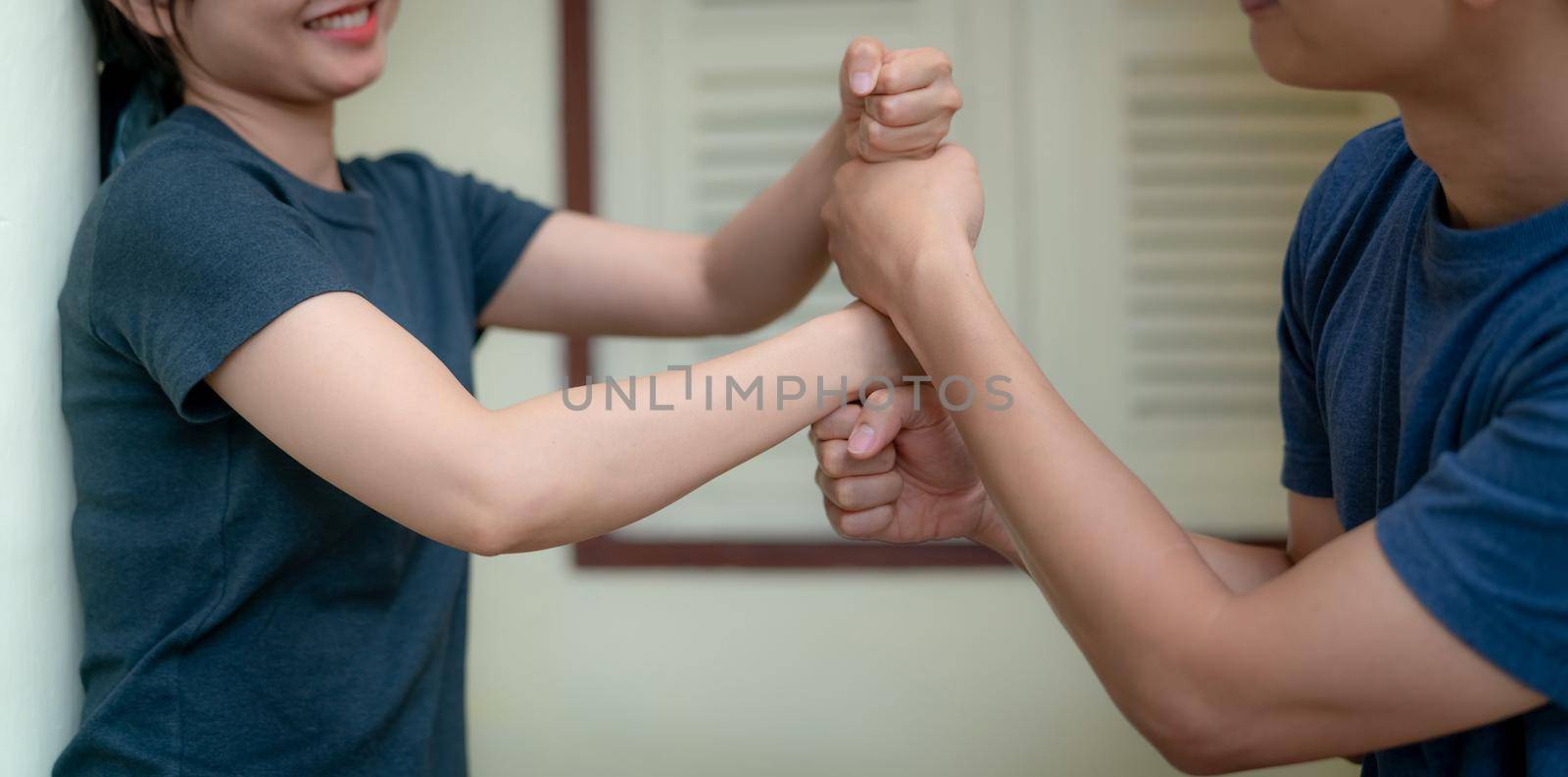 Happy young adult couple putting their fist on top of each other and smiling. Happy marriage. Family team building. Health insurance for couples. Trust and support together love couple. Life living. by Fahroni