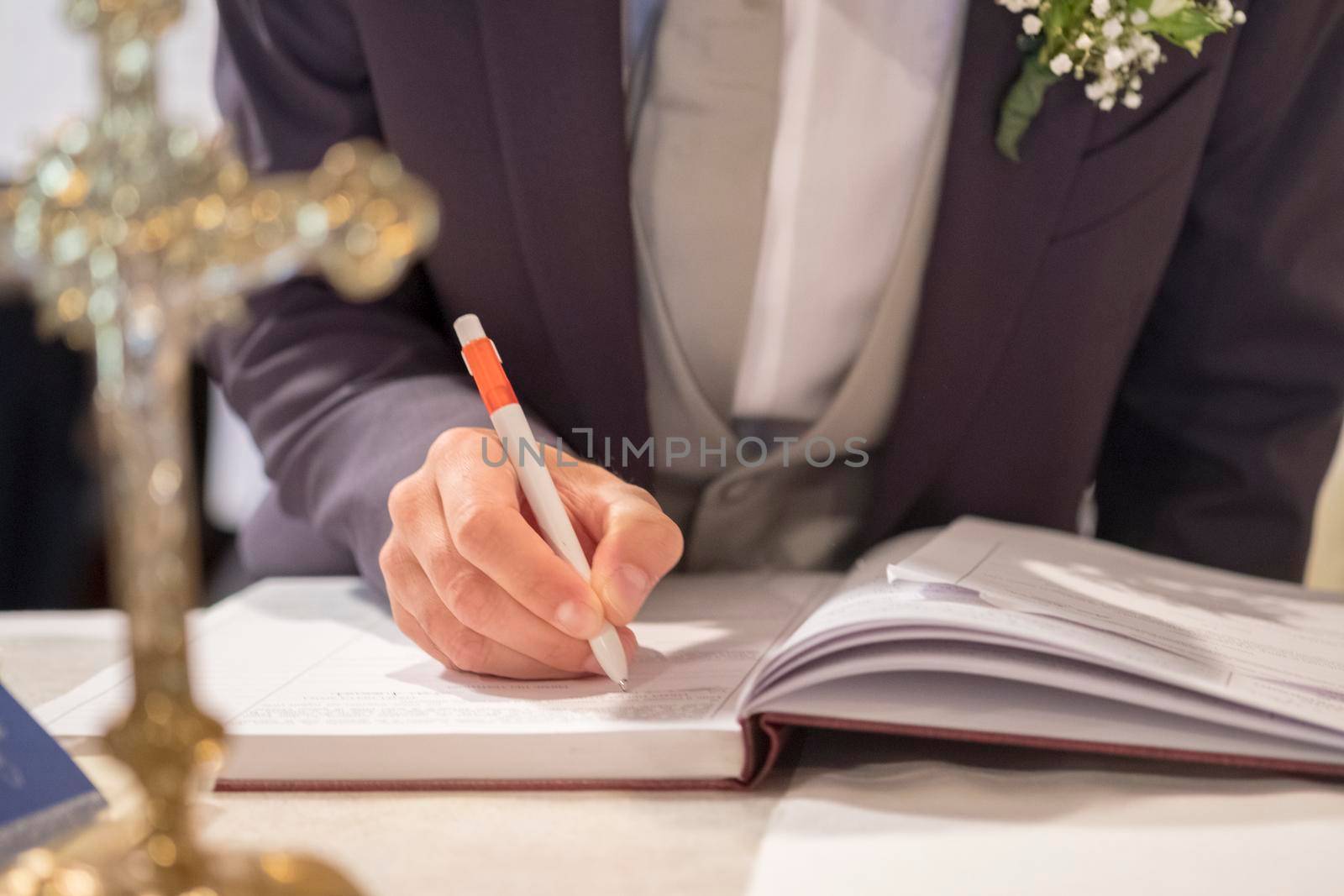 wedding best man groom signing register in catholic wedding. High quality photo