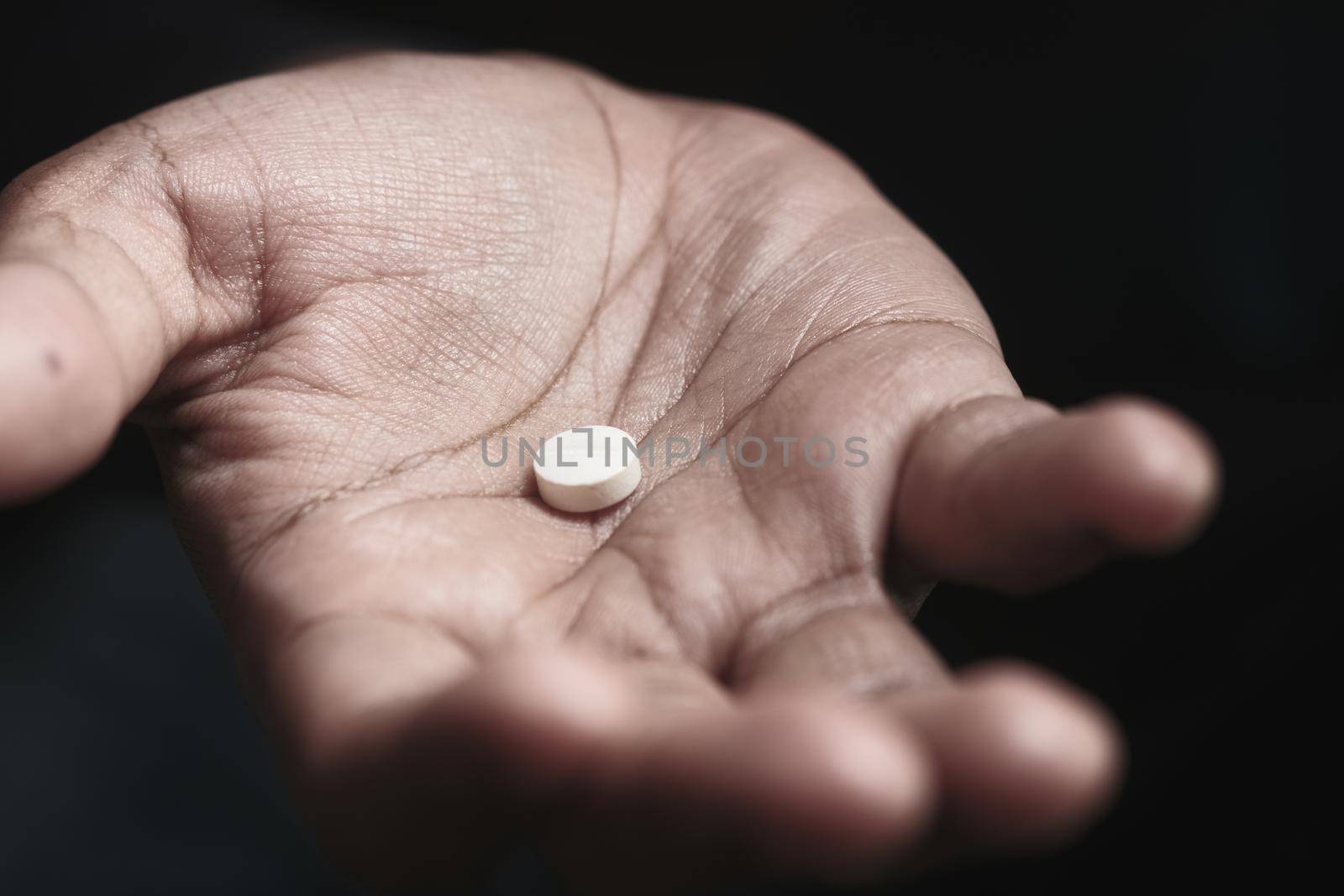 Close up of man hand holding pills with copy space .
