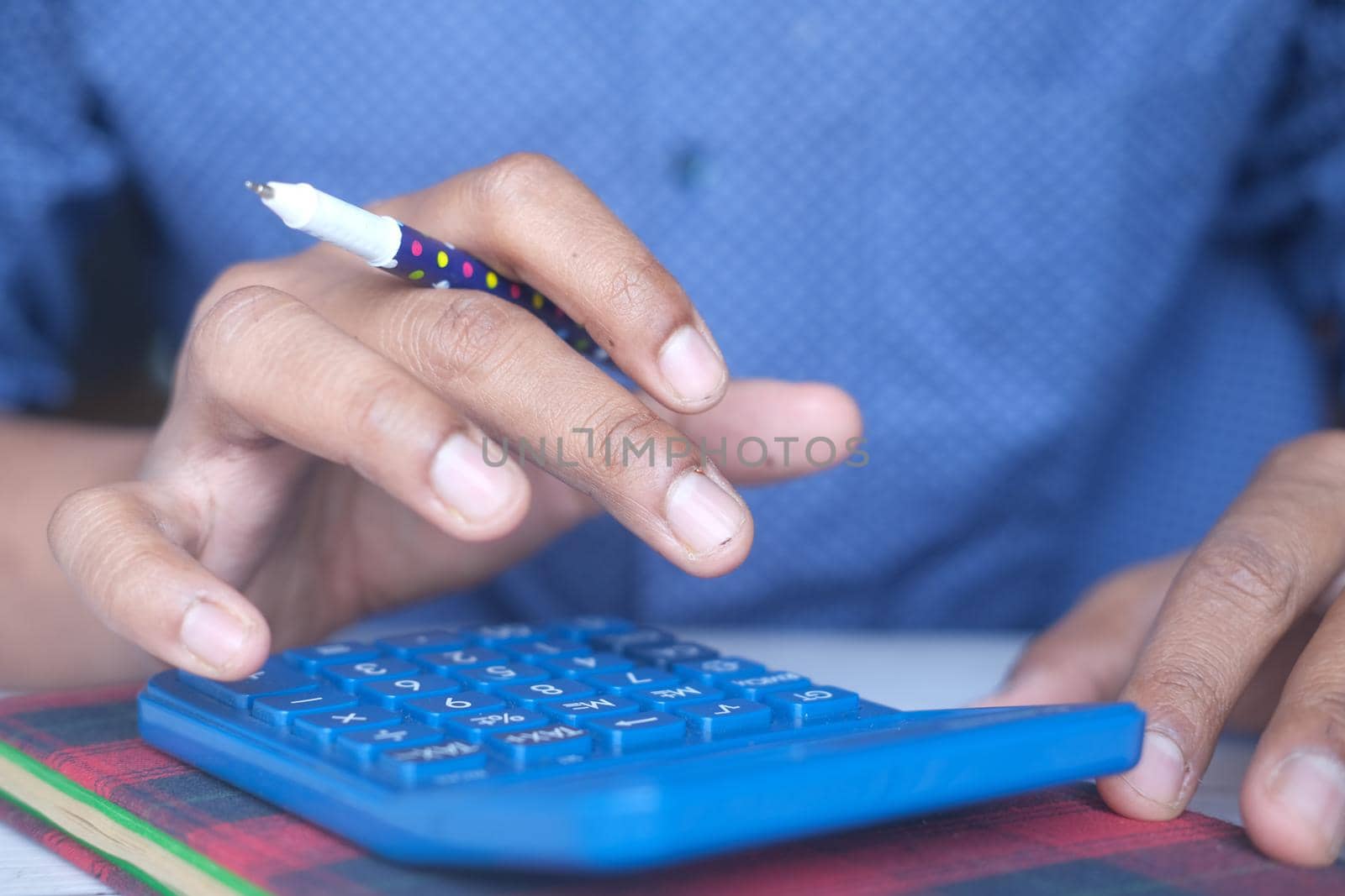 Close up of man hand using calculator.