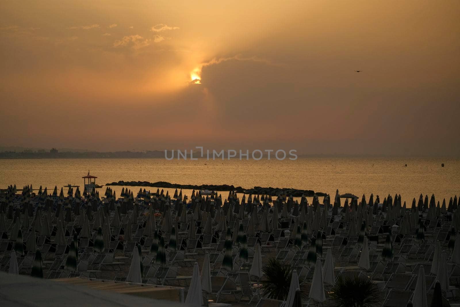 Rimini beach at sunset with yellow sky Riviera Romagnola. High quality photo