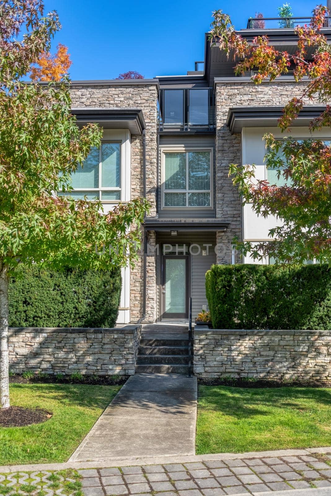 Entrance of residential townhouse with paved pathway in front.