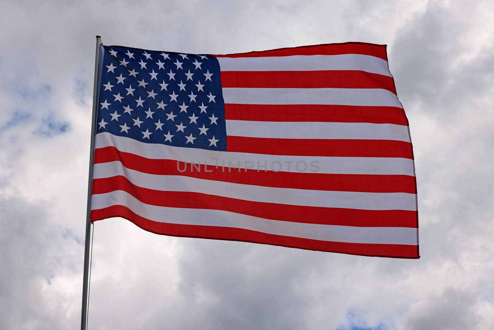 US American flag waving in stormy cloudy sky by BreakingTheWalls