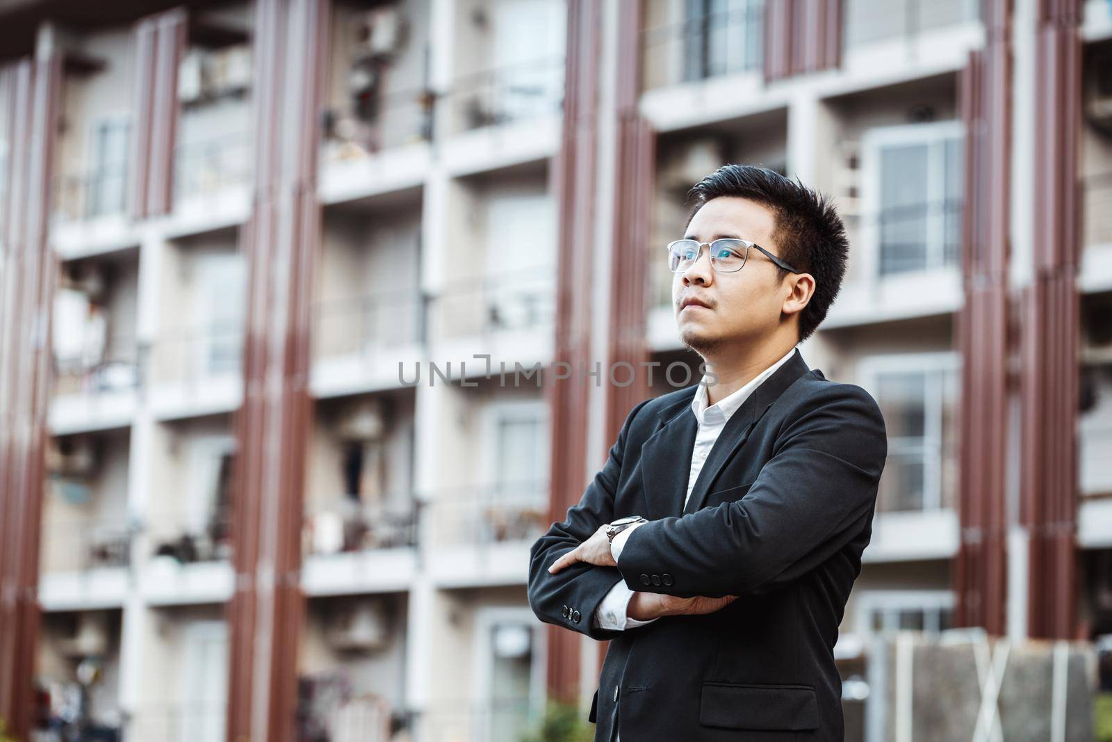 Portrait of a smiling handsome businessman with arms folded.