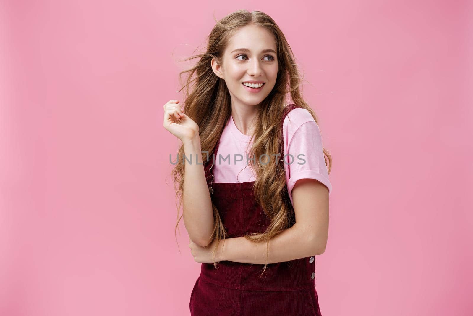 Girl looking like start from glamour magazines posing over pink background feminine and sensual looking right with flirty smile playing with hair while strands flicking in air by Benzoix
