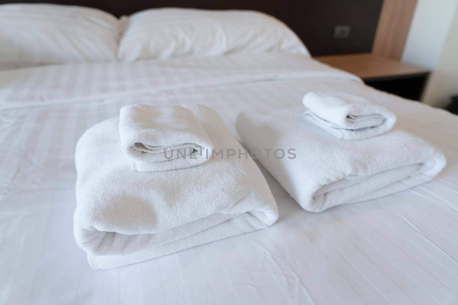 Stack towel set on bed in modern bedroom at hotel by Buttus_casso