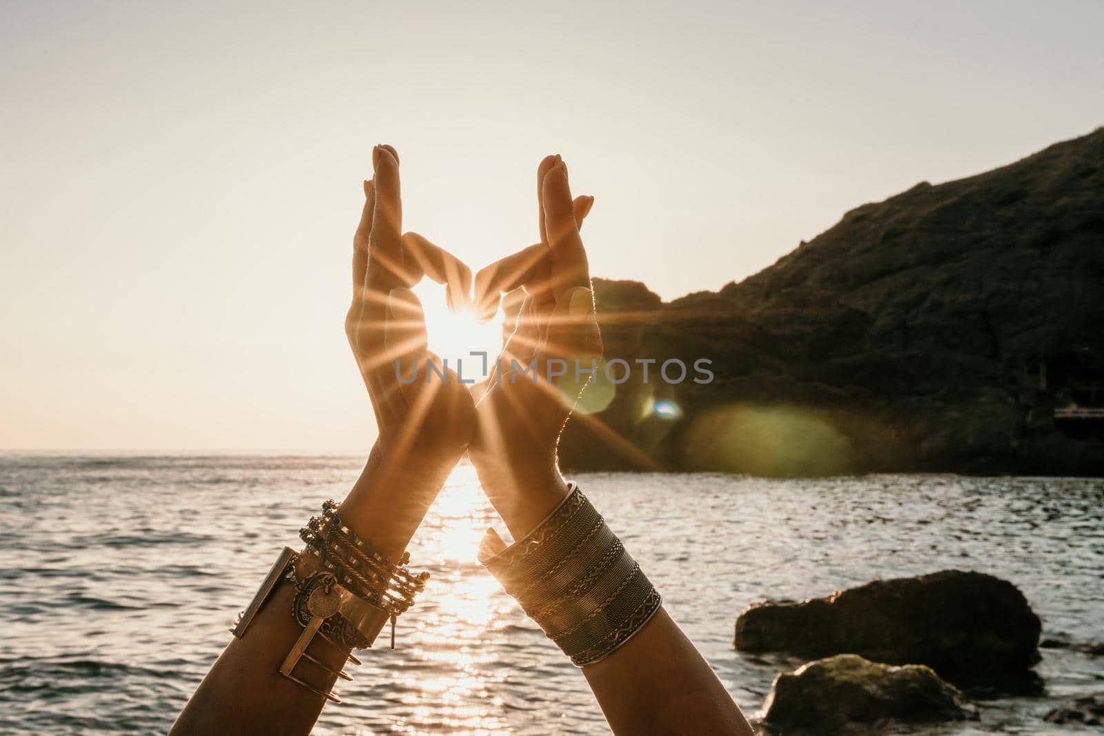 Young woman in swimsuit with long hair practicing stretching outdoors on yoga mat by the sea on a sunny day. Women's yoga fitness pilates routine. Healthy lifestyle, harmony and meditation concept.