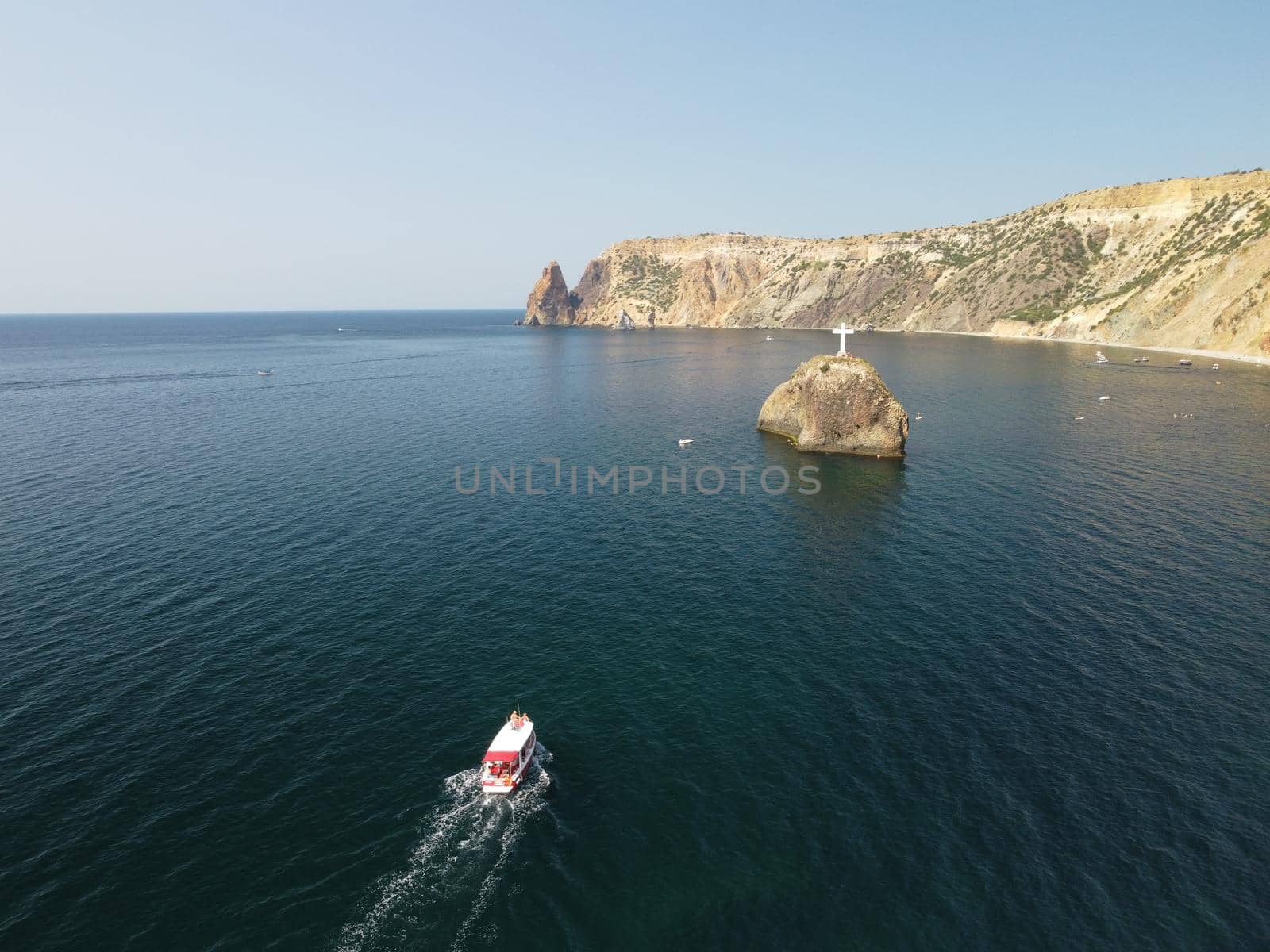 Aerial view from above on calm azure sea and volcanic rocky shores. Small waves on water surface in motion blur. Nature summer ocean sea beach background. Nobody. Holiday, vacation and travel concept by panophotograph