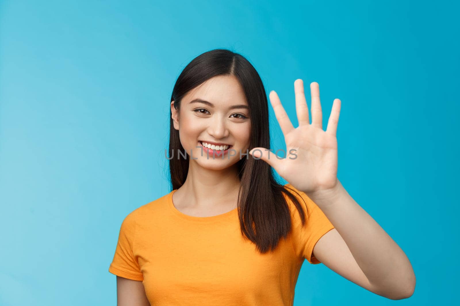 Close-up good-looking friendly cheerful asian woman raise palm show number five, fifth, smiling joyfully, describe how many things need, stand blue background upbeat, communicate. Copy space