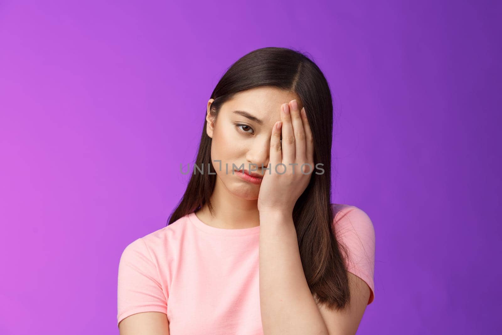 Close-up tired upset girl feeling loser, punch face, make facepalm sign sighing sorrow, exhausted doing hard homework, stand unhappy purple background, regret missed chance. Copy space