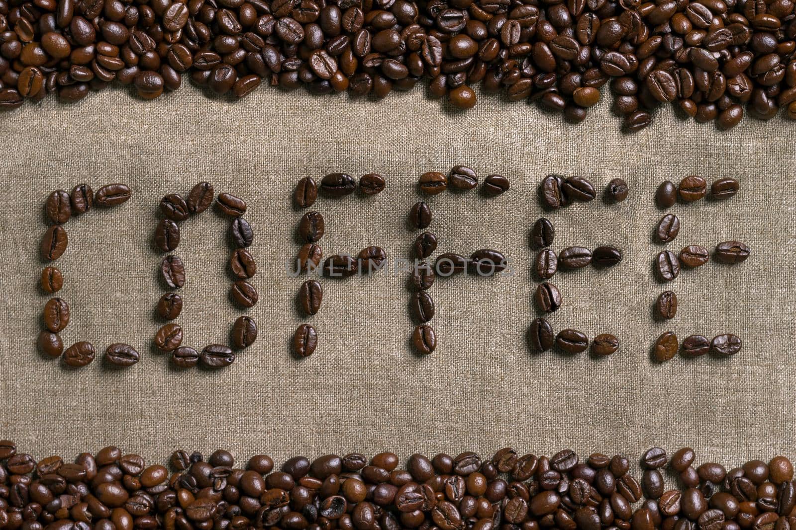 Inscription of coffee with coffee beans on burlap background