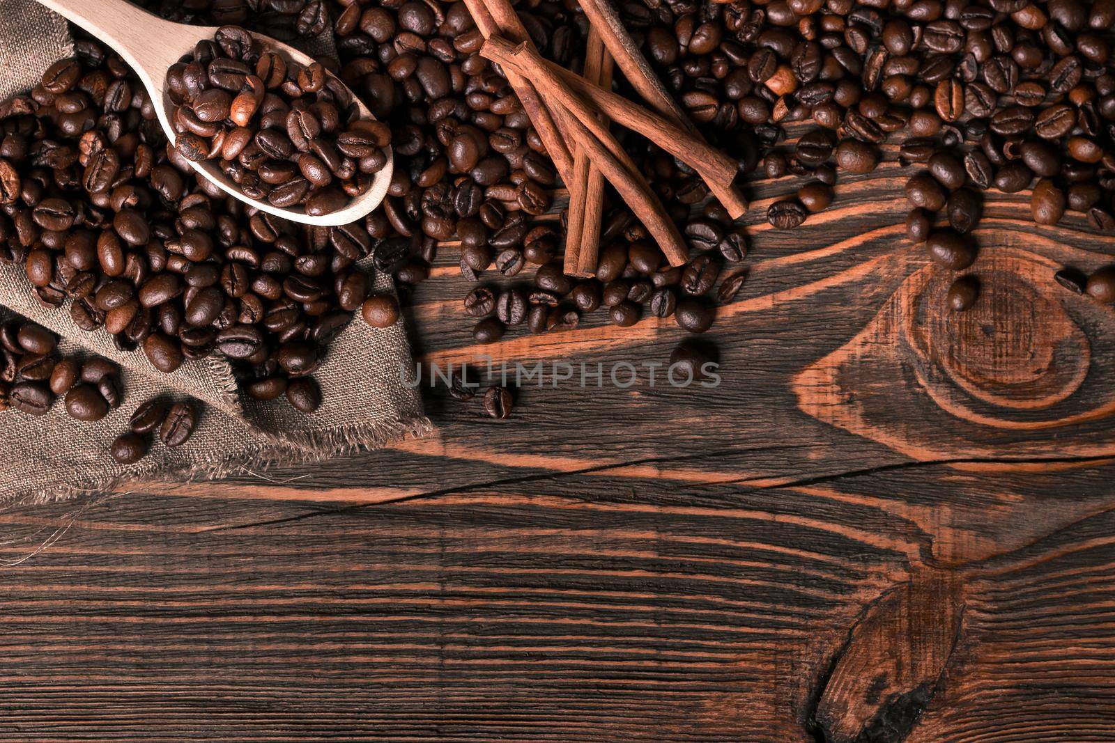 Wooden spoon with coffee beans on wooden table background with c by nazarovsergey