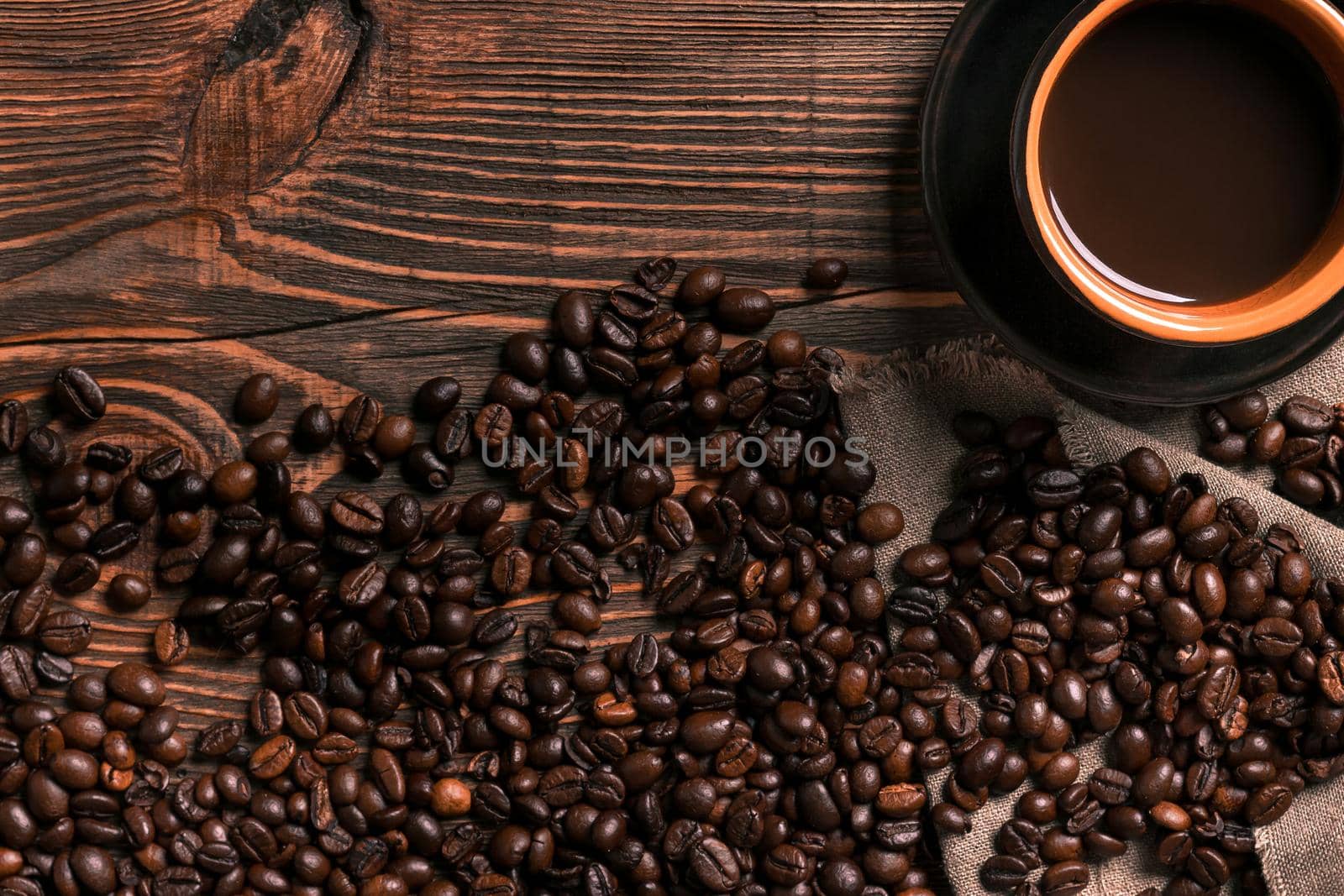 Coffee cup and beans frame on wooden table. Top view. Copy space. Still life. Mock-up. Flat lay