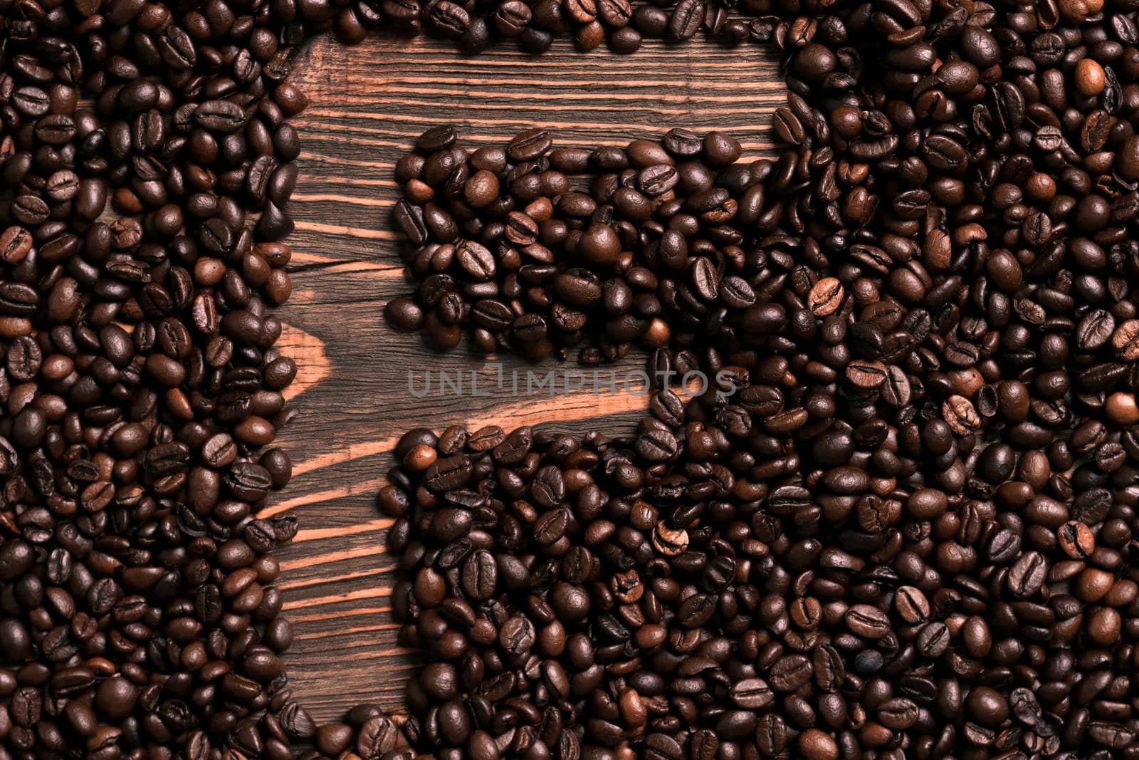 Letter F inscription with coffee bean on the wooden table. Top view. Copy space. Still life. Mock-up. Flat lay