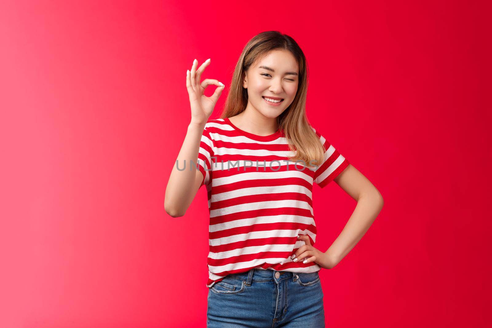 Good job mate. Proud happy female coworker approve your effort show okay gesture winking joyfully congratulate friend excellent plan, say well done make ok good approval gesture, red background by Benzoix