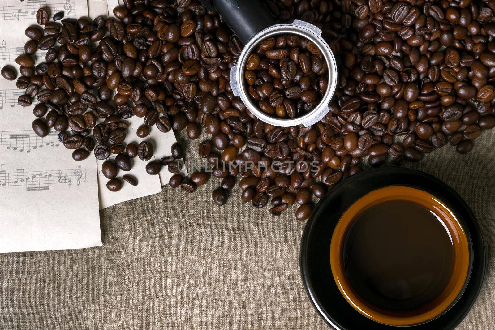 Coffee beans, sheet music and Coffee cup on a burlap background. Top view. Copy space. Still life. Mock-up. Flat lay