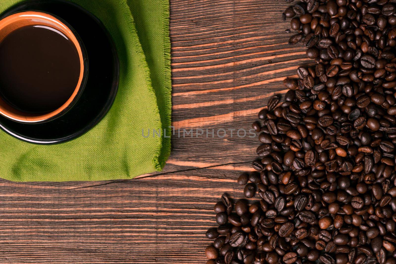Coffee cup and coffee beans on wooden background. Top view. Still life. Copy space. Flat lay.