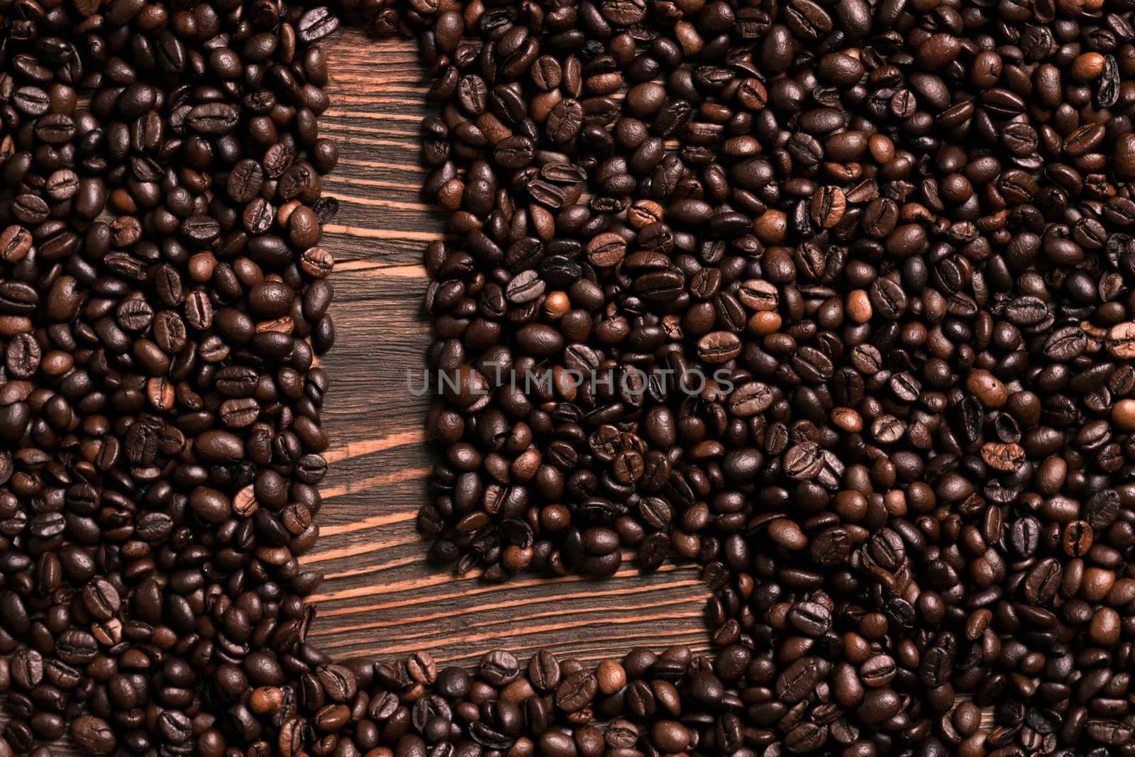 Letter L inscription with coffee bean on the wooden table. Top view. Copy space. Still life. Mock-up. Flat lay